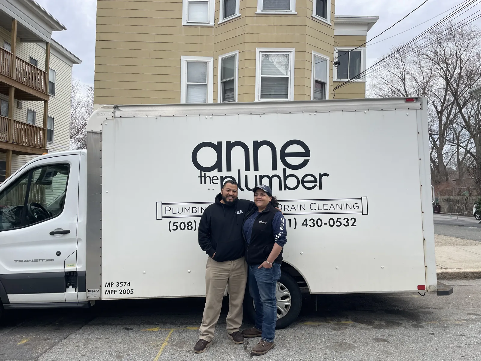 Wilson and Anne standing in front of the Anne the Plumber service truck