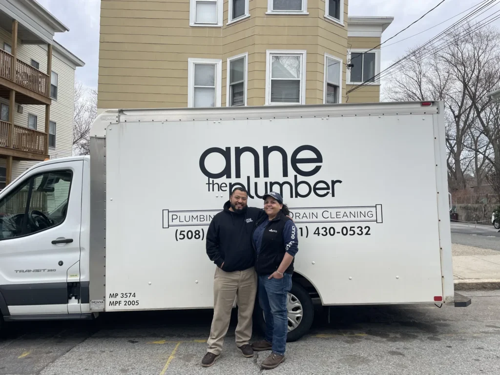 Wilson and Anne standing in front of the Anne the Plumber service truck